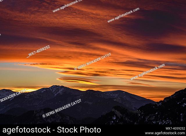 Red sky with windy clouds over the summits of Tosa d'Alp and Puigllançada, seen from the Cadí north face (Cerdanya, Catalonia, Spain, Pyrenees)