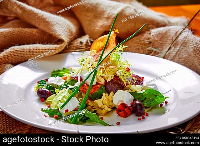 Fresh spring salad with feta cheese, red onion in white bowl. background with free text space