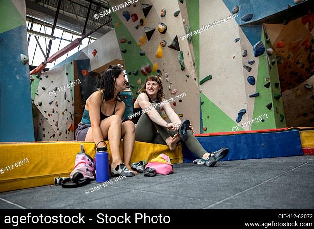 Young female rock climbers preparing in climbing gym