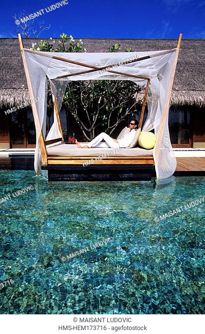 Maldives, North Male Atoll, One and Only Reethi Rah Hotel, girl relaxing on the edge of the private swimming pool of her beach villa