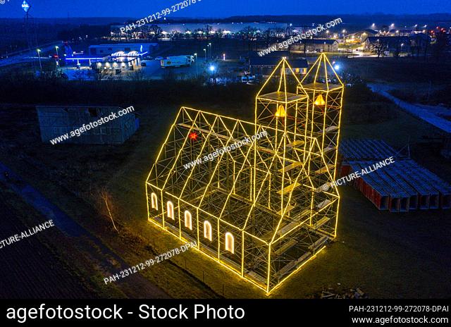 12 December 2023, Mecklenburg-Western Pomerania, Fahrbinde: The Christmas church, erected by scaffolders in the last few days and illuminated with fairy lights