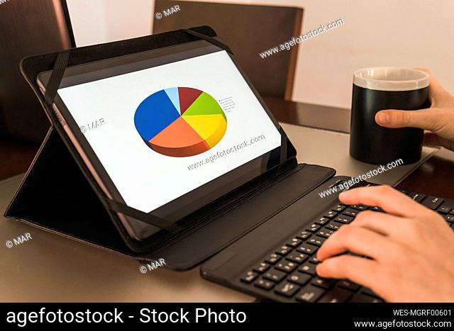 Hands of businesswoman using tablet PC analyzing graph at office