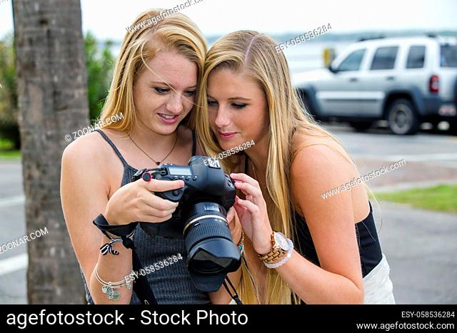 Two teenage sisters looking at photos on a digital camera