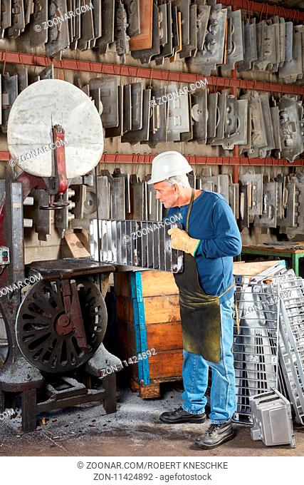 Älterer Mann als Arbeiter in einer Fabrik für Metallbau sucht nach passender Gussform
