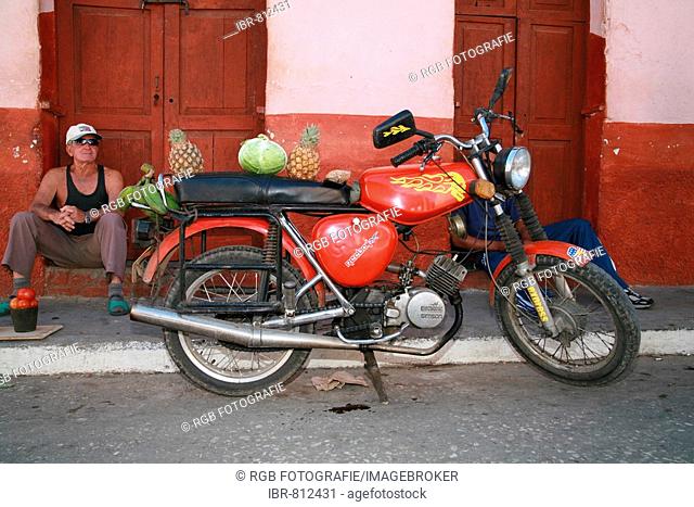 Salesman using his motorbike as a sales booth on a street in Trinidad, Sancti-Spíritus Province, Cuba, Latin America