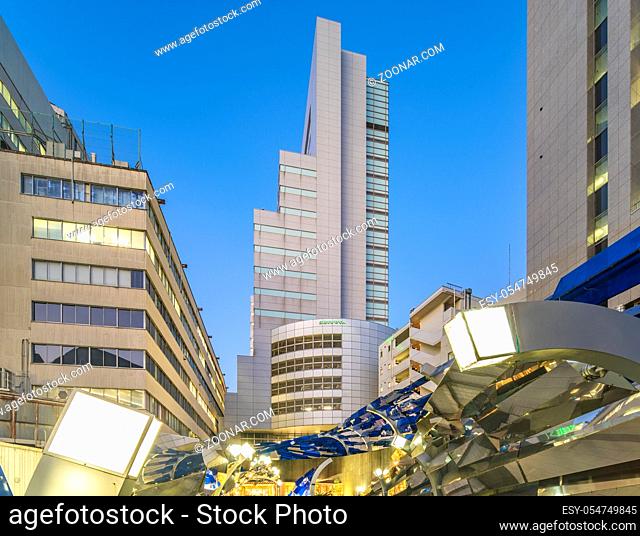 Futuristic architecture with mirroring and transparent blue plastic panels swiveling in Shibuya district in Dogenzaka street leading to Shibuya Crossing...