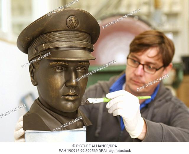 16 September 2019, North Rhine-Westphalia;Hesse, Mülheim: Technician Michael Lenz ((Ego3D) applies bronze paint to the prototype of the 3D head of the Elvis...