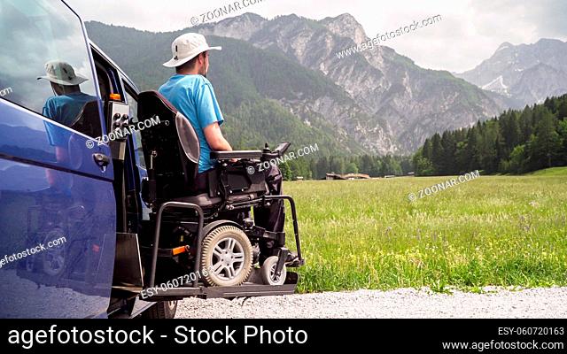 electric lift specialized vehicle for people with disabilities. Empty wheelchair on a ramp with nature and mountains in the back