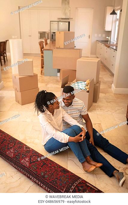 Happy African American couple sitting on floor and talking with each other