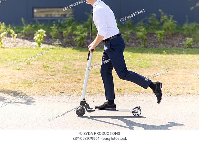 young businessman riding electric scooter outdoors