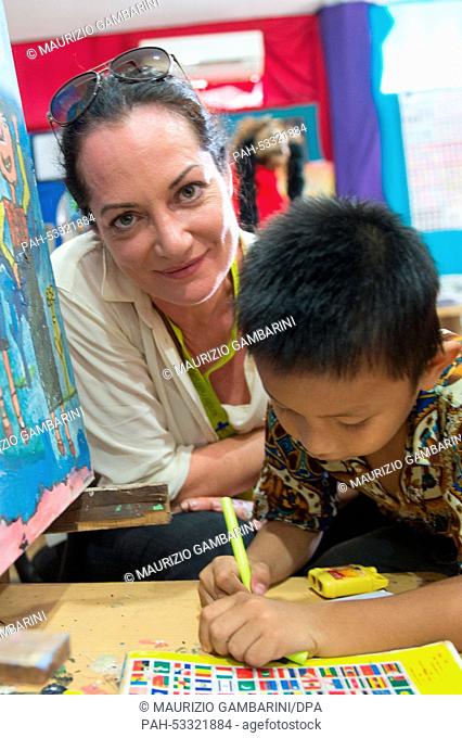 Actress Natalia Woerner paints with Jason, a former street kid, in Jakarta,  Indonesia, 03 November 2014. She supports Kindernothilfe