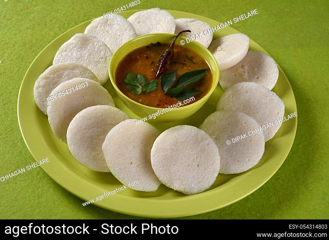 Idli with Sambar in bowl on green background, Indian Dish : south Indian favourite food rava idli or semolina idly or rava idly