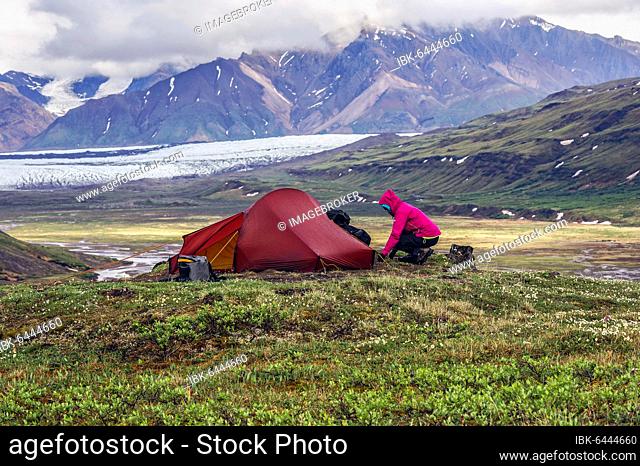 Woman next to tent, Wrangell St. Elias Mountains, behind Russell Glacier, Alaska, USA, North America