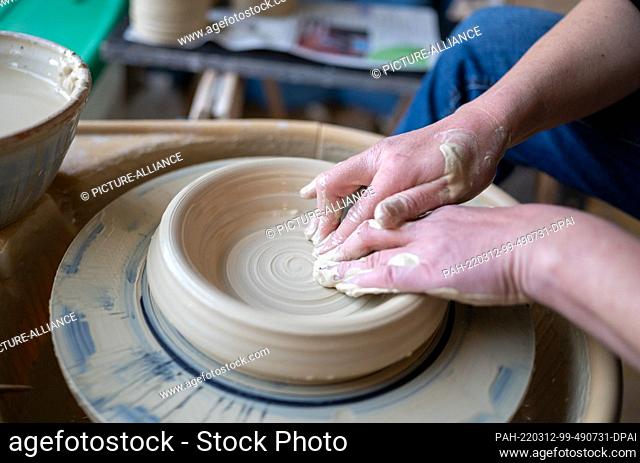 12 March 2022, Lower Saxony, Winsen (Aller): Kerstin Hübner-Bartels, molds a vase with her hands at the potter's wheel. Under the motto ""Look, touch, marvel