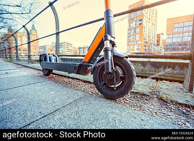 Germany, Hamburg, an e-scooter leaning against a railing
