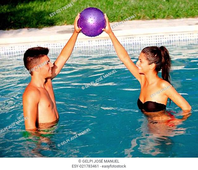 Happy couple relaxing in the pool playing with a ball
