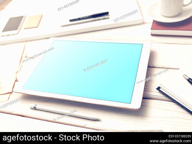 Tablet device mockup with stylus and office supplies on the office desk. Clipping path included
