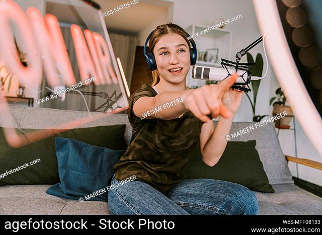 Girl broadcasting on microphone at home