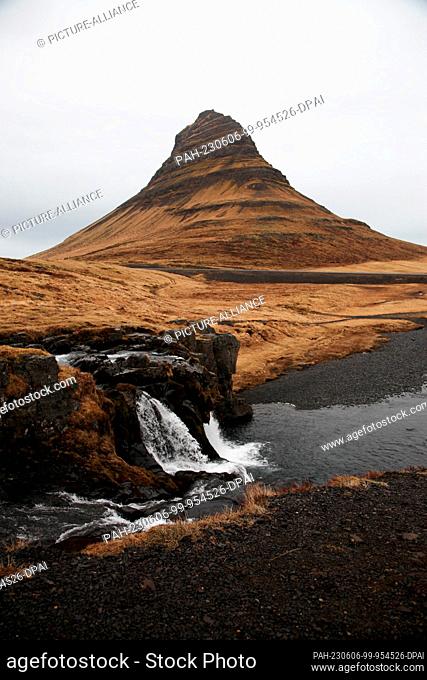 FILED - 16 April 2023, Iceland, Grundarfjördur: Kirkjufell mountain rises high on the Snæfellsnes peninsula in Iceland. In front of it you can see the...