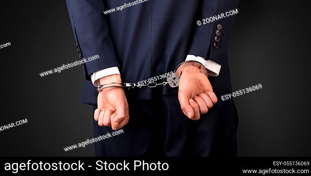 Close now arrested men hand with dark background and handcuffs