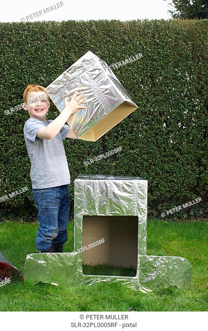 Boy building cardboard spaceship