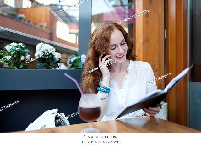 Elegant woman in cafe using mobile phone