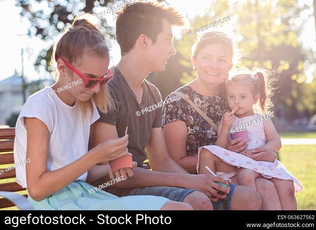 Family spending time together in the city centre eating ice cream on a summer day