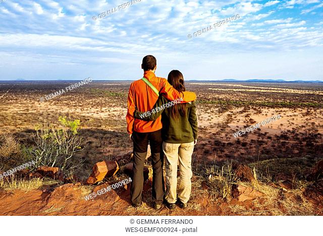 Namibia, embracing couple overlooking the vast plains in the african savannah from a natural viewpoint