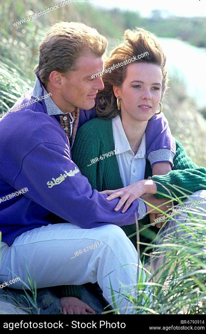 Lovers sitting in the grass, with cardigan