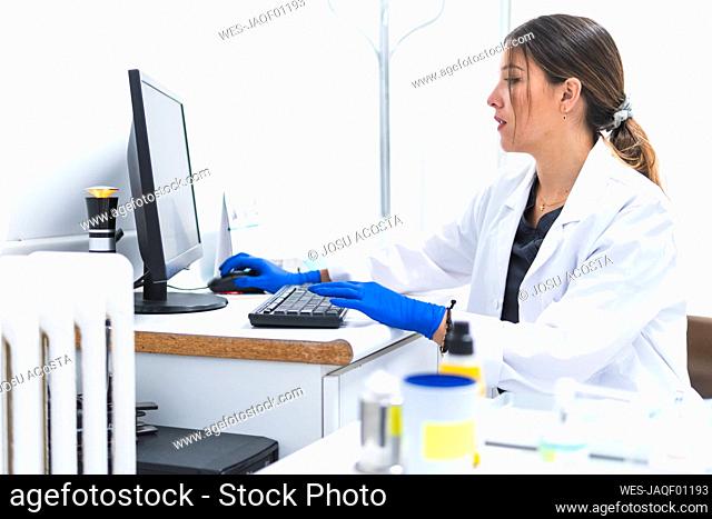 Dentist working on computer at desk in office