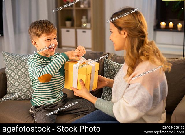 mother giving present to her little son at home