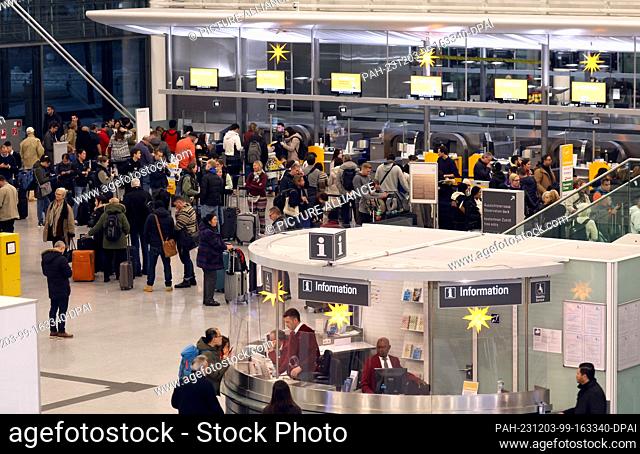 03 December 2023, Bavaria, Munich: Passengers stand at check-in at Munich Airport. Munich Airport resumed flight operations at 06:00 on Sunday