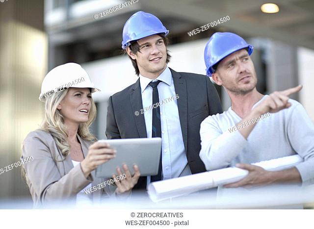 Team of architects having meeting at construction site