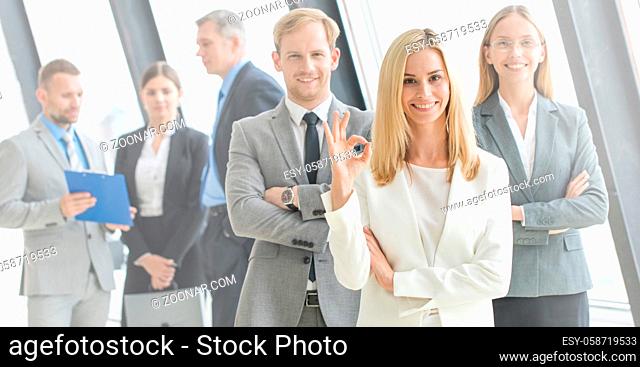 Business, people, gesture and teamwork concept - smiling businesswoman showing ok sign with group of businesspeople in office