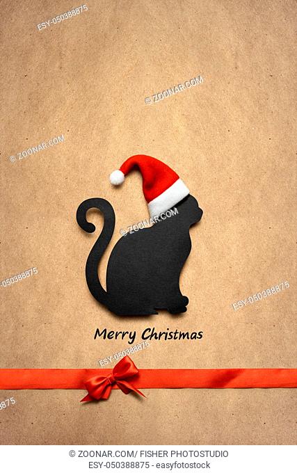 Creative concept photo of christmas cat in the hat with sign on brown background