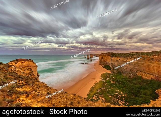 Australia, Victoria, Long exposure of sandy beach in Port Campbell National Park at cloudy dawn