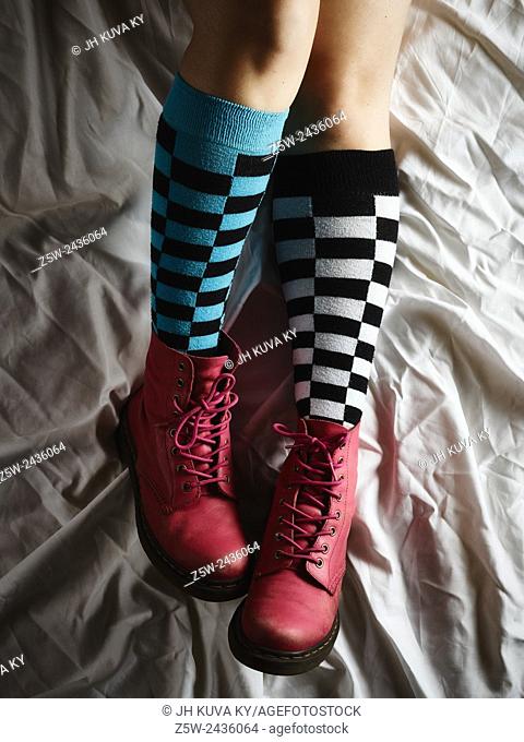 Girl lying on the bed and she wearing the socks and the pink shoes
