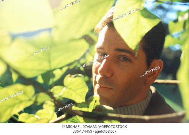 Man behind leaves