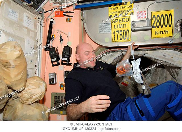 European Space Agency astronaut Andre Kuipers, Expedition 30 flight engineer, is pictured near food and beverage packages floating freely in the Unity node of...