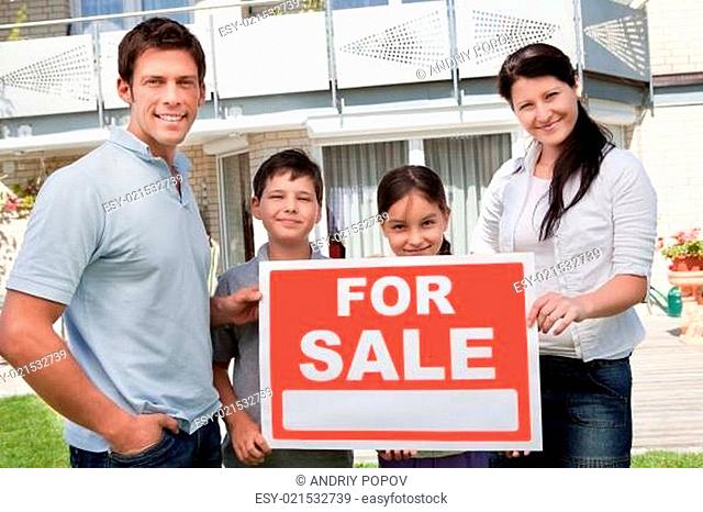 Young family selling their home with sale sign