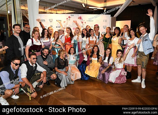 19 September 2022, Bavaria, Munich: Presenter Cathy Hummels (center, below, in dark blue skirt) shows off with her friends at Hotel Roomers before her Wiesn...