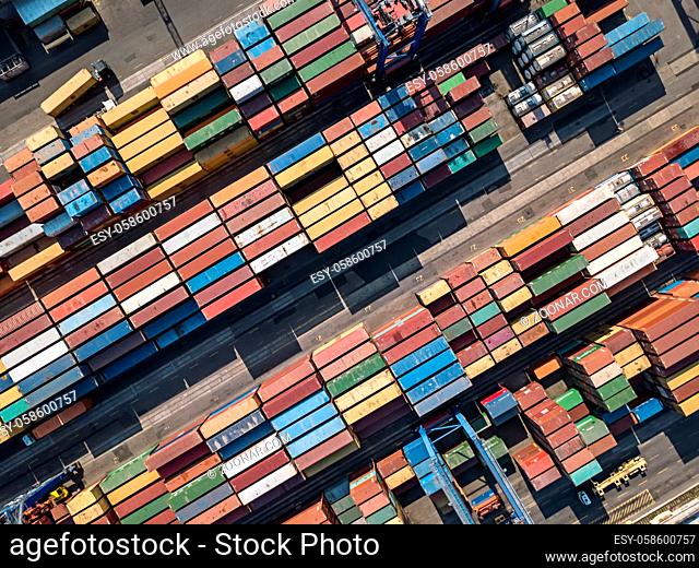 View from above at the warehouse with many multicolored containers. There are cranes and trucks. Horizontal photo. Outdoors