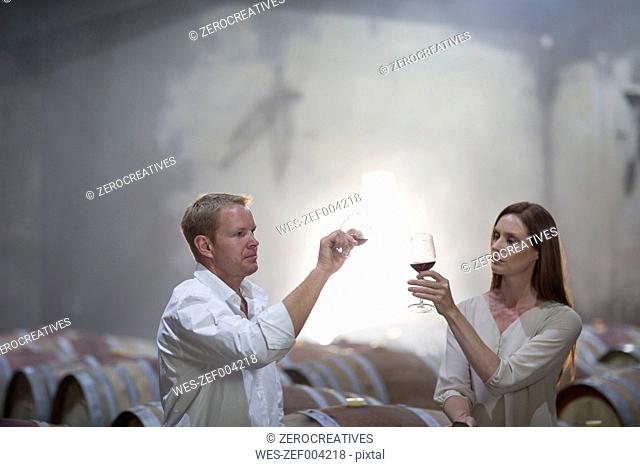 Man and woman tasting wine in cellar