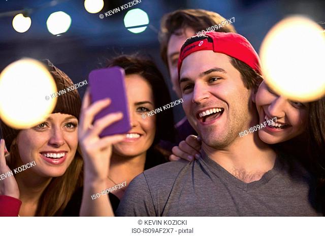 Young adult friends taking selfie at party