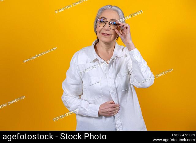 Positive mood. Positive and determined senior woman in light shirt