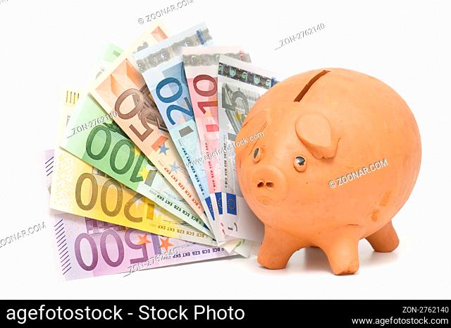piggy bank savings and euro banknotes on white background