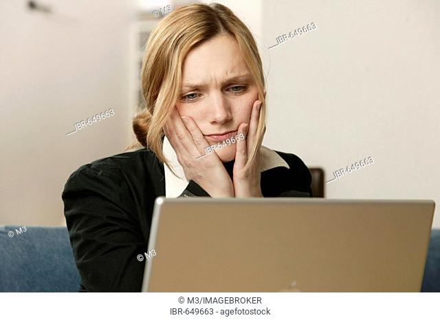 Annoyed blonde woman with laptop