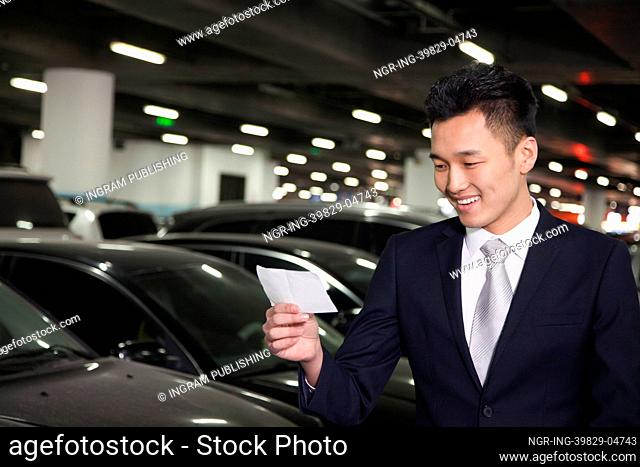 Traveler looking at ticket in airport parking lot