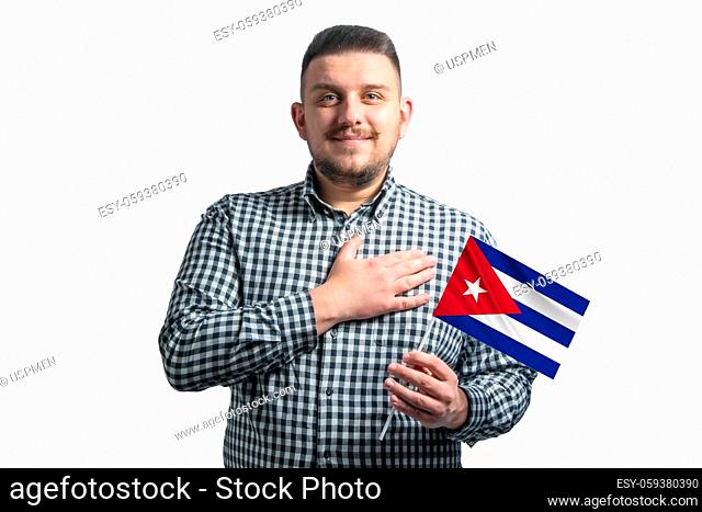 White guy holding a flag of Cuba and holds his hand on his heart isolated on a white background With love to Cuba