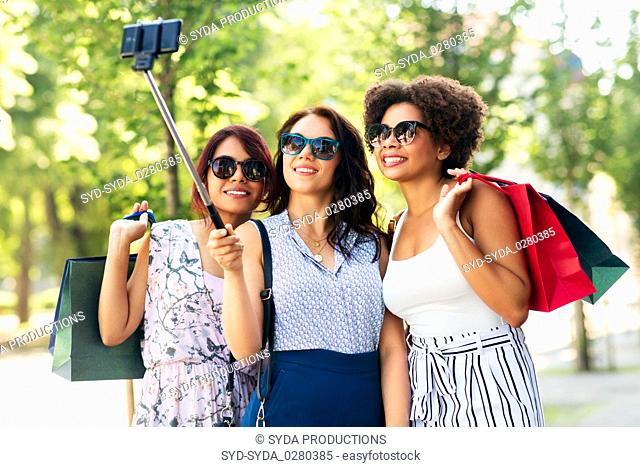 women with shopping bags taking selfie outdoors